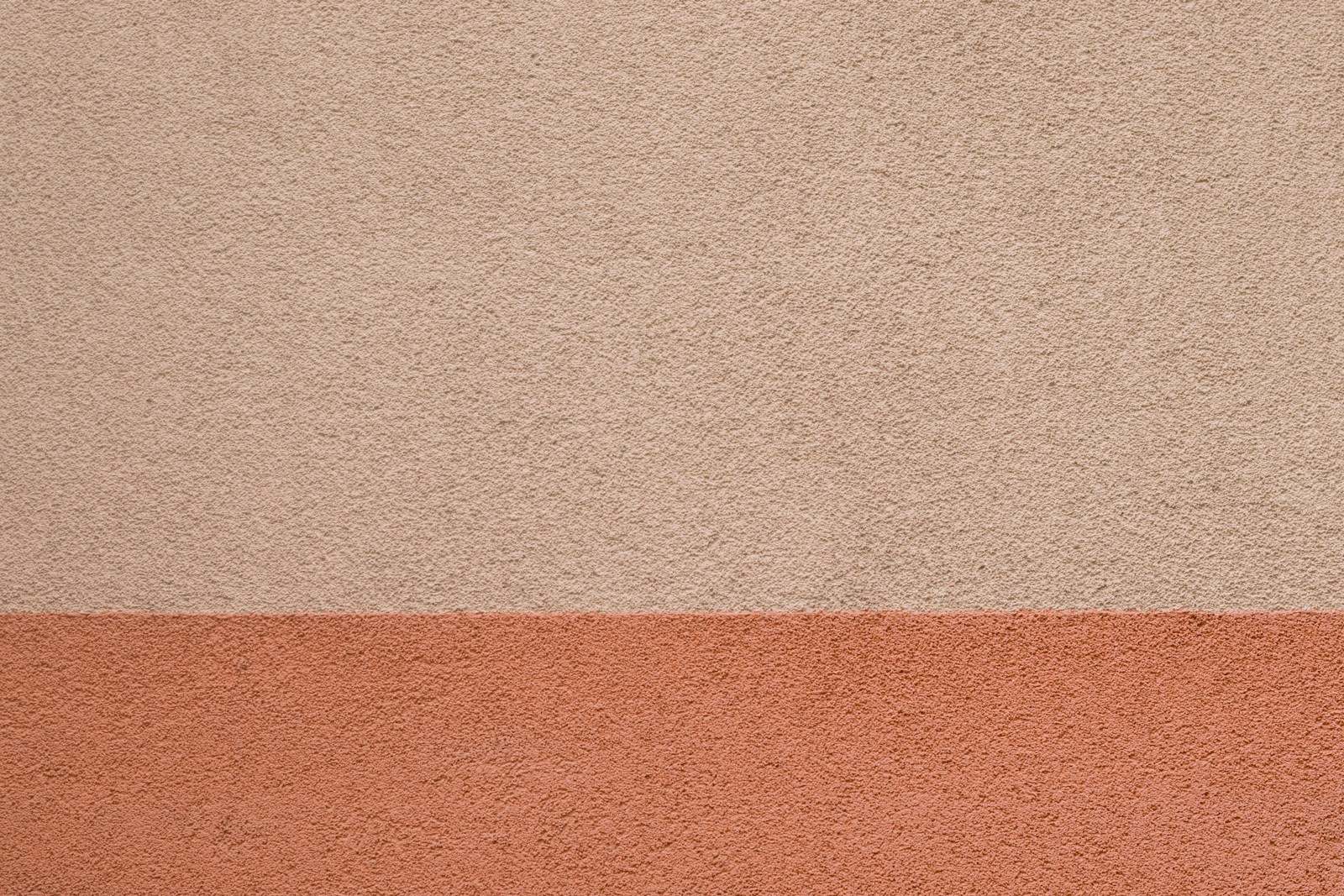 Gevelpleister in twee tinten: lichtroze boven en terracotta onderaan